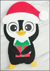 paper penguin with santa hat and present