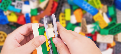 child's hands assembling lego blocks